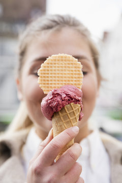 Woman's hand holding ice cream cone, close-up