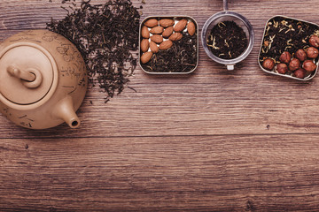 Tea strainer with tea on a wooden surface. Green and black tea Top view with copy space