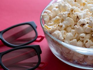 Poporn in bowl with a 3d glasses on red