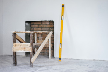 Construction grunge ladder, and the building yellow level : white wall and gray floor. Apartment decoration concept.
