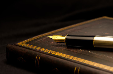 万年筆と古びた本 / Still life image of a fountain pen and an old book.