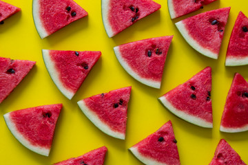 Pieces of red watermelon on yellow background.