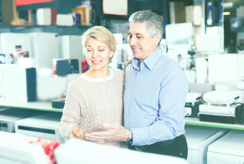 Man and woman 48-56 years old are visiting shop of household app