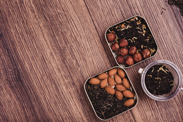 Tea strainer with tea on a wooden surface. Green and black tea Top view with copy space