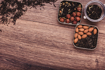 Tea strainer with tea on a wooden surface. Green and black tea Top view with copy space