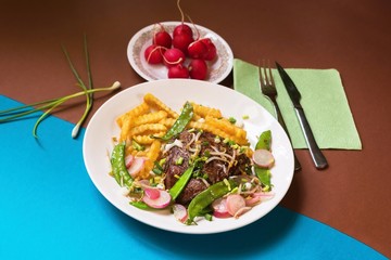 Beefsteak, french fries, pea legume, raw radish, sprout.
