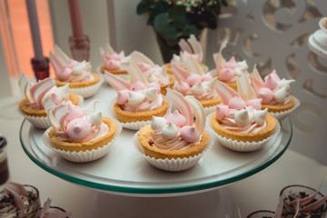 glass stand with cupcakes on a wedding candy bar table