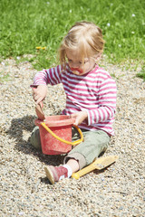 Child little girl playing with toy shovel and bucket