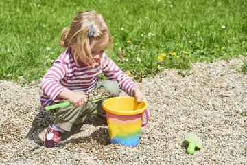 Child little girl playing with toy shovel and bucket