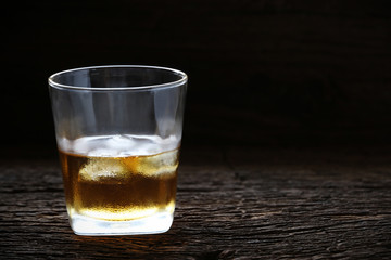 whiskey with ice cubes served on Old wood table