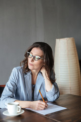 Thoughtful woman writer sitting indoors