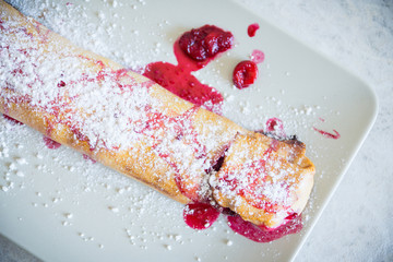 Strudel with cherry on white table. Shallow depth of field.