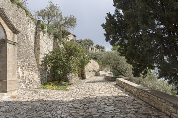 Cobblestone road road near stone walls, at seaside, in Greece, on The Holy Athos mountain. Spring time.