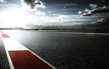 Racetrack with red and white safety sideline ,dramatic cloudy sky and cold mood filter apply .