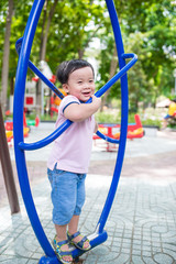 Happy little boy having fun at playground in summer.