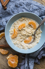 Healthy breakfast - oatmeal with slices of tangerines