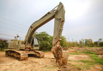 Fototapeta na wymiar Excavator or backhoe at the construction site with Pale sky