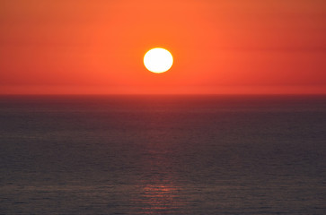 Sunset, red sky and dark sea surface