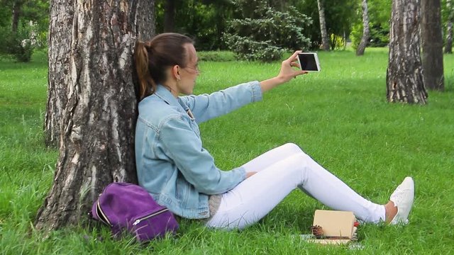 Girl Takes Pictures Of Herself On Phone In The Green Forest