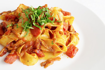 pasta with bacon, tomato, and onion decorated with parsley