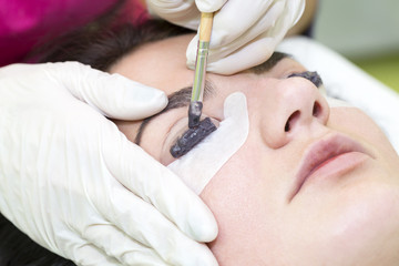 Woman on the procedure for eyelash extensions, eyelashes lamination 