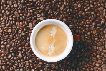 Coffee beans on a black background. Raw coffee beans. Grained product. Hot drink. Close up. Harvesting. Natural background. Energy. In the middle of picture is coffee cup 