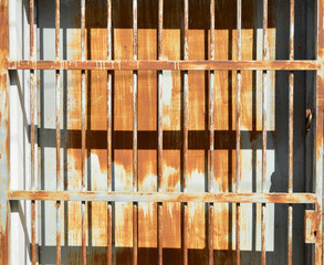Rusty metal sheet door with grille