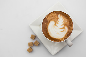 Top view of coffee cup on white background. mug of cappuccino with sugar top view. Flat lay. Copy space.
