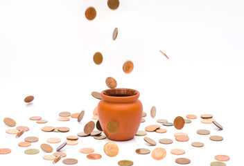 many copper coin fall down around a brown vase. investment, business, saving money concept.