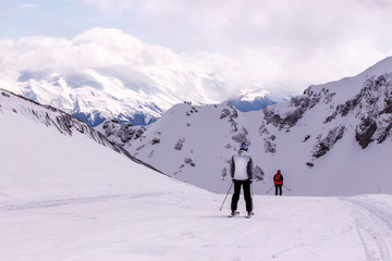 skiers and snowboarders on the slope in the mountains