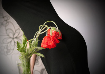A beautiful bouquet of red poppies on a silhouette of a lady