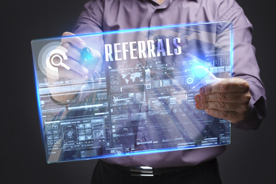 Business, Technology, Internet and network concept. Young businessman working on a virtual screen of the future and sees the inscription: Referrals