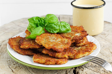 Fried potato pancakes decorated with basil leaves