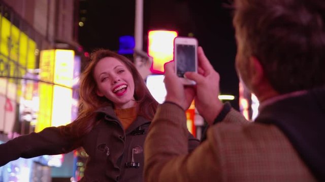 Couple taking photos in Times Square, New York City