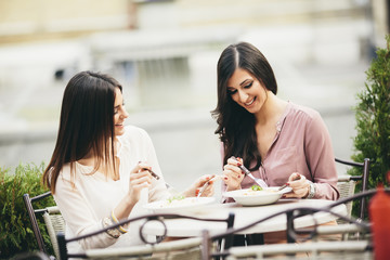 Pretty young women having lunch in the restaurant outdoor