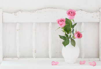 pink rose on white wooden shelf