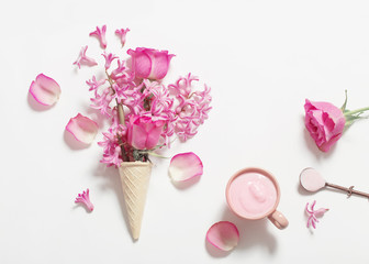 Flowers in a waffle cone with yogurt on white background