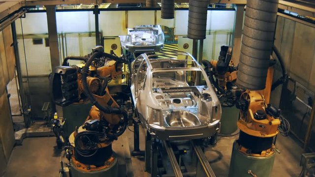 robots are welding the car body, making car body on a automobile factory