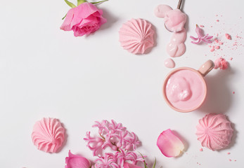 Flowers in a waffle cone with yogurt and meringues on white background