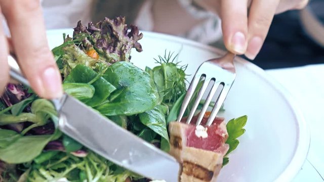Eating tuna and lettuce Nicoise salad at the restaurant, haute cuisine. 4K close-up video