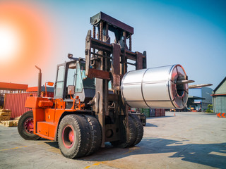 The forklift is handling big coil to warehouse after unstuffing from container.