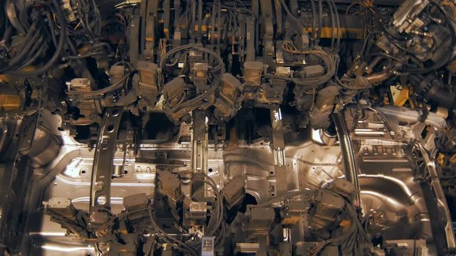 robots weld car body on a car factory, top view, sparks and lights