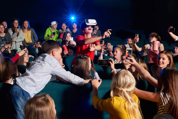 Young boy looking amazed and surprised pointing away with his finger wearing virtual reality...