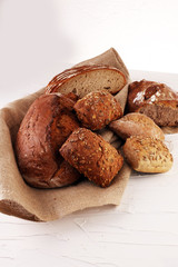 Different kinds of bread and bread rolls on board from above. Ki