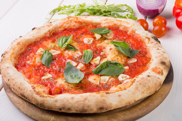 Whole pizza on wooden board