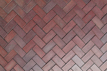 Texture of a red paving stone lined with zigzag - wave