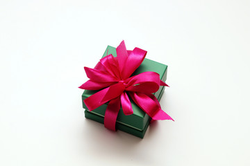 Green gift box with a red bow on a white background.