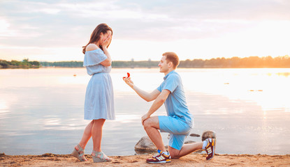 Marriage proposal on sunset . young man makes a proposal of betrothal to his girlfriend