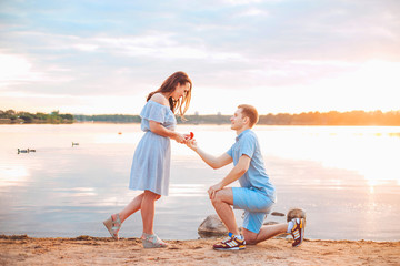 Marriage proposal on sunset . young man makes a proposal of betrothal to his girlfriend