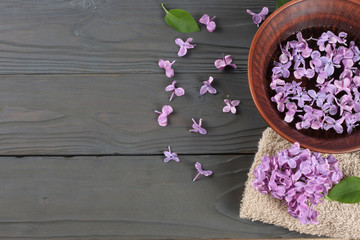Fototapeta na wymiar spa lilac flower in water on wood background
